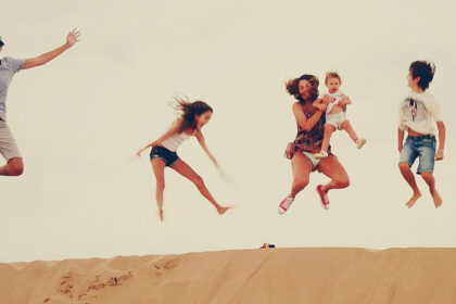 Family enjoying the dunes in the merzouga desert during their Morocco vacation